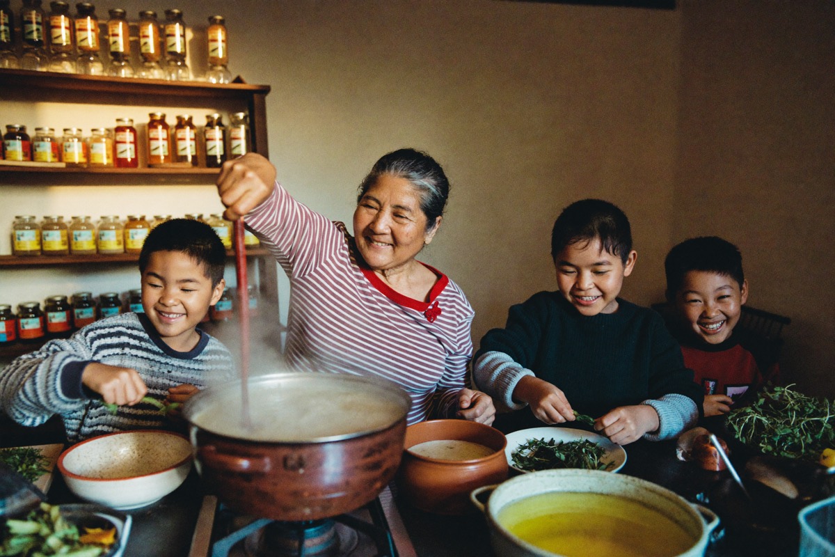 A family cooking a big pot meal together